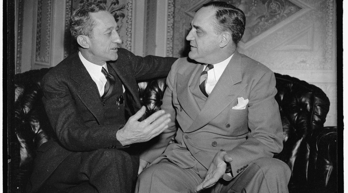 Historic 1940 photograph of Senator Carl Hatch of New Mexico, author of the Hatch Act, seated in conversation with Senator Sherman Minton of Indiana